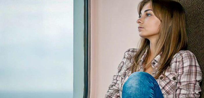 joven sentada junto a la ventanilla del tren mostrando signos de ansiedad anticipada