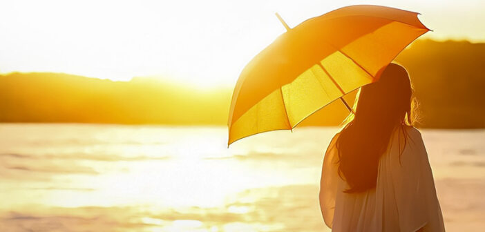 mujer con sombrilla mirando el sol ilustrando los aspectos de la vida