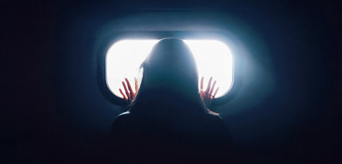 mujer en la oscuridad mirando por la ventana - significando la soledad