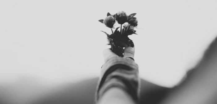 una persona sosteniendo flores para simbolizar la muerte