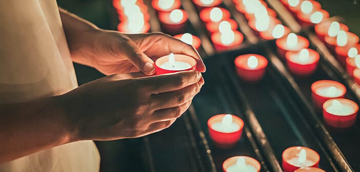 persona encendiendo una vela para un ser querido muerto