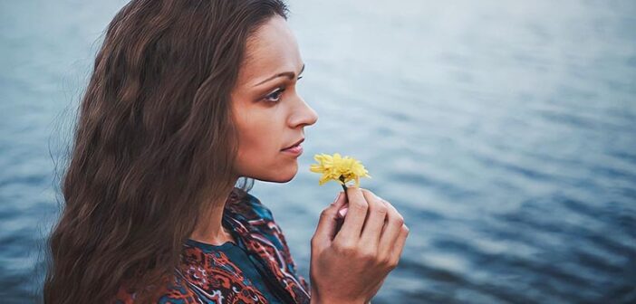 mujer joven que huele la flor pero no puede disfrutarla ni nada