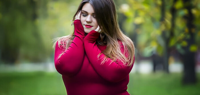 mujer empática joven y curvilínea en suéter rojo con cabeza