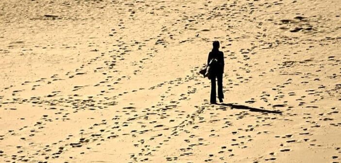 cómo encontrarse de nuevo cuando está perdido: silueta de persona caminando sola en una playa de arena