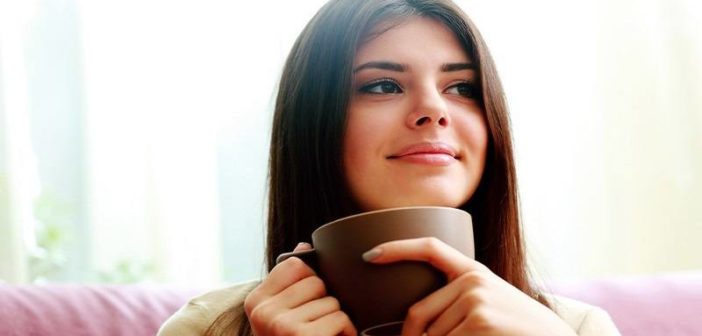 mujer bebiendo café con una sonrisa en la cara mostrando que ha vuelto a ser feliz