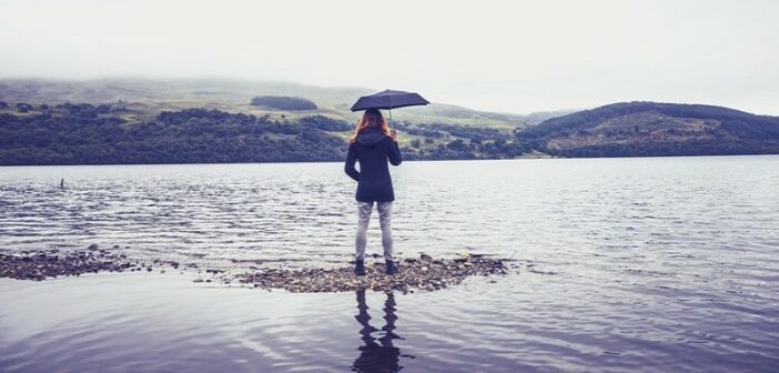 mujer con paraguas en el lago - concepto siendo humilde
