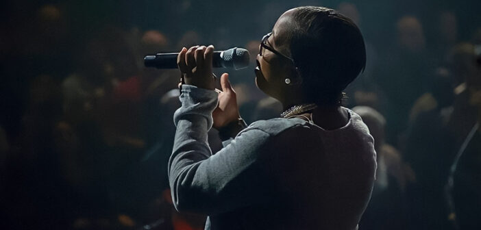 imagen de una mujer negra cantando al micrófono - concepto de canciones inspiradoras y motivadoras