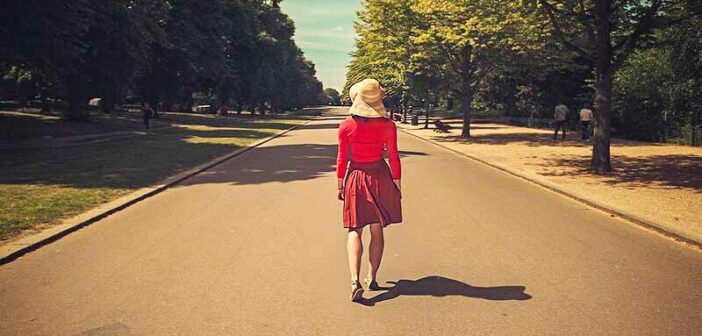mujer de rojo caminando por una calle vacía, ilustrando una transición de vida