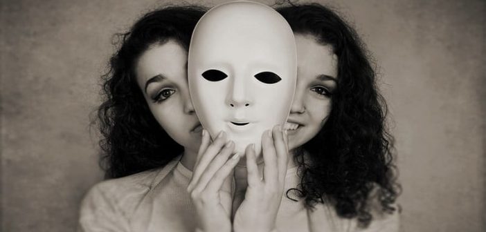 young woman with happy and sad face behind mask - showing mood swings