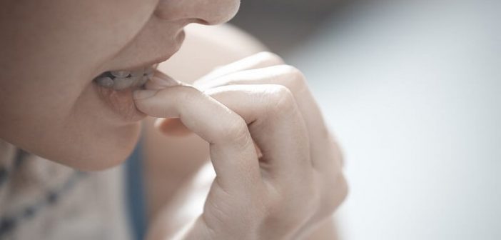 mujer mordiendo las uñas un ejemplo de hábito nervioso