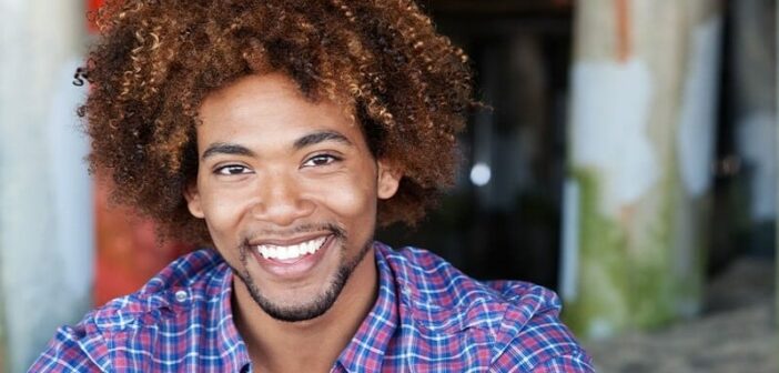 Hombre afroamericano sonriendo, ilustrando las buenas cualidades a buscar en un hombre