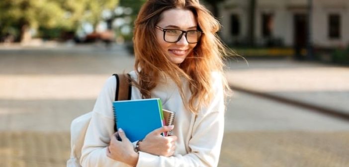 mujer joven con gafas con libros que ilustran a una persona reservada