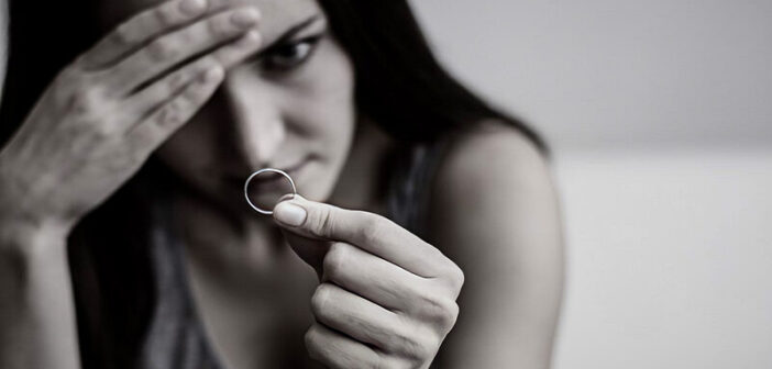 mujer triste mirando el anillo de bodas decidiendo cuándo alejarse después de la infidelidad