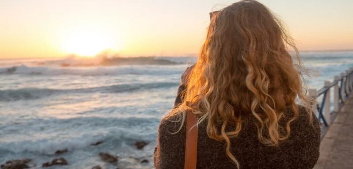mujer mirando el amanecer sobre el océano ilustrando la esperanza